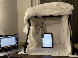 A hotel room luggage rack provides structure for pillows and blankets.